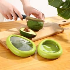 Fresh avocado being sliced on a wooden cutting board with a knife, with avocado slicers in the foreground. Ideal for healthy eating, avocado lovers, and kitchen tools for preparing nutritious meals.