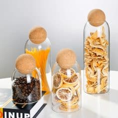 Colorful glass jars containing cookies, nuts, dried citrus slices, pasta, and chips displayed for a stylish store presentation.