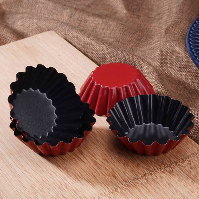 Silicone baking cups in red and black on wooden surface, perfect for desserts and muffins, stylish kitchen accessories for baking enthusiasts.