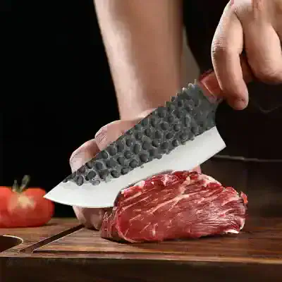 Premium chef's knife slicing fresh raw beef for cooking or preparation, emphasizing high-quality kitchen tools and culinary techniques.