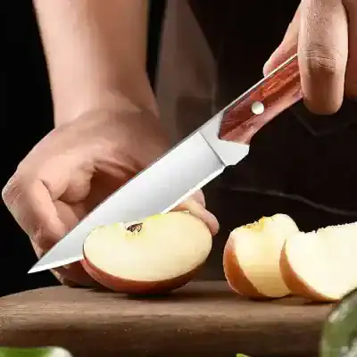 Sharp kitchen knife slicing an apple on a wooden cutting board, focus on food preparation, culinary tools, healthy eating, cooking, and kitchen essentials.