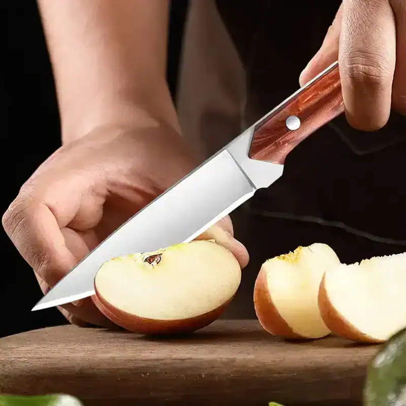 Sharp kitchen knife slicing an apple on a wooden cutting board, focus on food preparation, culinary tools, healthy eating, cooking, and kitchen essentials.