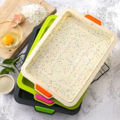 Colorful baking trays stack on a kitchen counter with baking ingredients and eggs around, ideal for preparing delicious desserts and pastries at Monalisa Store.