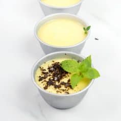 Creamy vanilla pudding cups with chocolate crumbs and fresh mint garnish, perfect for dessert at Monalisa Store. Delicious, smooth, and visually appealing treats for all occasions.