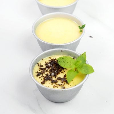 Creamy vanilla pudding cups with chocolate crumbs and fresh mint garnish, perfect for dessert at Monalisa Store. Delicious, smooth, and visually appealing treats for all occasions.