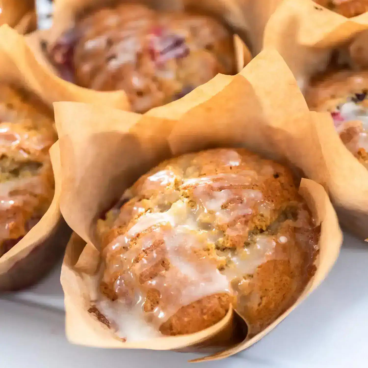 Creamy cinnamon-spiced muffins with icing, fresh baked in parchment paper cups, perfect for breakfast or snack. Ideal for bakery, dessert, and sweet treat lovers.