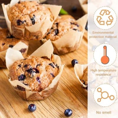 Golden blueberry muffins in parchment paper liners on wooden surface, fresh blueberries scattered around.