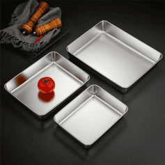 Stainless steel baking trays with a ripe tomato on one, featuring sleek, professional kitchen cookware ideal for baking, roasting, and food preparation. Perfect for commercial and home use.