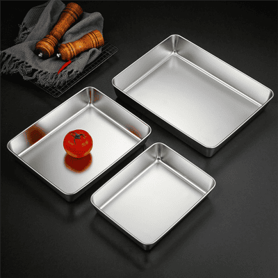 Stainless steel baking trays with a ripe tomato on one, featuring sleek, professional kitchen cookware ideal for baking, roasting, and food preparation. Perfect for commercial and home use.