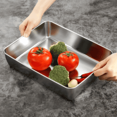 Fresh tomatoes, broccoli, garlic, and peppers arranged in a stainless steel tray, healthy vegetables for nutritious meals.
