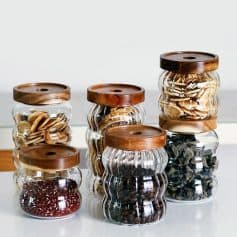 Glass jars with wooden lids filled with various supplements, herbs, and natural remedies for eye health and vision support at Monalisa Store.