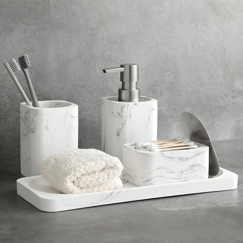 Elegant marble bathroom accessories set including toothbrush holders, soap dispenser, tissue box, and towel, perfect for modern and minimalist interior decor.