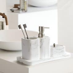 Elegant marble bathroom accessories including toothbrush holder, soap dispenser, and tray, perfect for modern optometry clinics and eyewear stores like Monalisa Store.