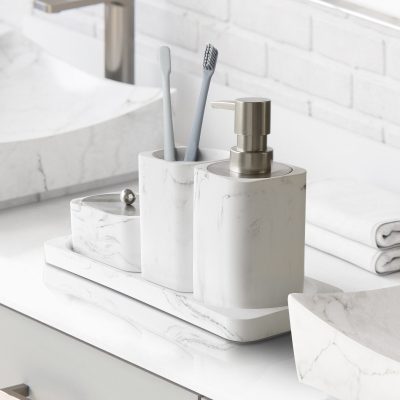 Soap dispenser and toothbrush holder set in elegant white marble bathroom accessories.