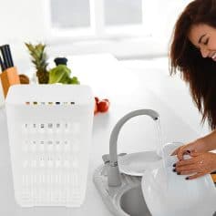 Bright young woman washing dishes at kitchen sink, natural light, clean modern kitchen, domestic cleaning, lifestyle, household chores, casual home interior, everyday activity, hygiene, kitchen utility, domestic work, lifestyle photography, cozy home atmosphere, interior design.