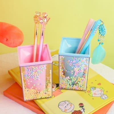 Colorful pen holders with decorative pens and stationery accessories, perfect for adding a fun and vibrant touch to your workspace or study area.