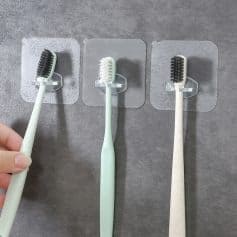 Toothbrushes displayed on transparent adhesive mounts for oral hygiene and dental care at Monalisa Store.