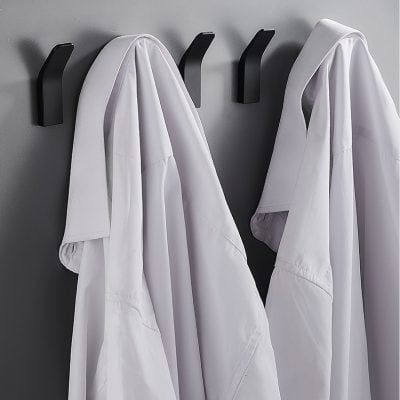 White lab coats hanging on black hooks at Monalisa Store, medical clothing, healthcare uniforms, professional medical attire, clean and professional medical wear, doctor and healthcare worker uniforms, medical practice essentials.
