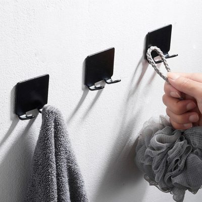 Hook wall organizer for keys, holiday accessories, or laundry, featuring sleek black hooks on a white wall, perfect for home storage.