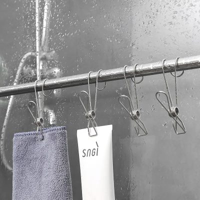 Clothesline with hanging cloth and tags inside a shower on a rainy day, showing waterproof and moisture-resistant fabrics ideal for bathroom or outdoor use.