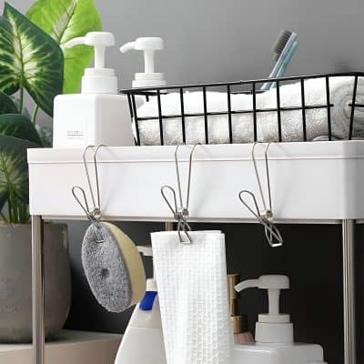 Clean and organized bathroom storage with skincare products, brushes, and towels in a modern workspace, ideal for maintaining personal hygiene and skincare routines.