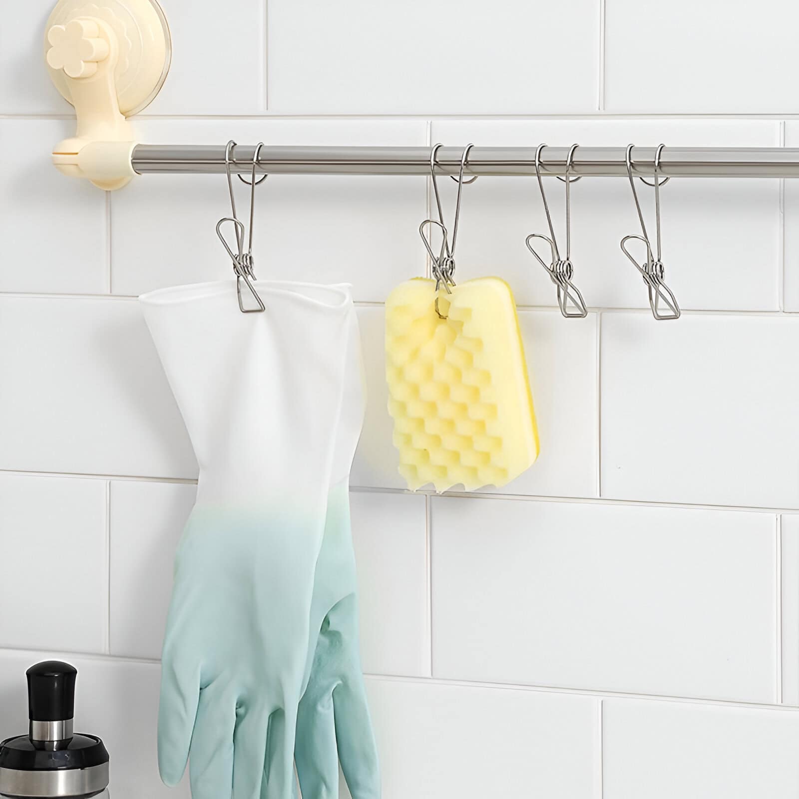 Bright white tile wall with stainless steel rod holding cleaning gloves, sponge, and hooks, clearly showing spotless and organized space at Monalisa Store for optical and eyewear products.