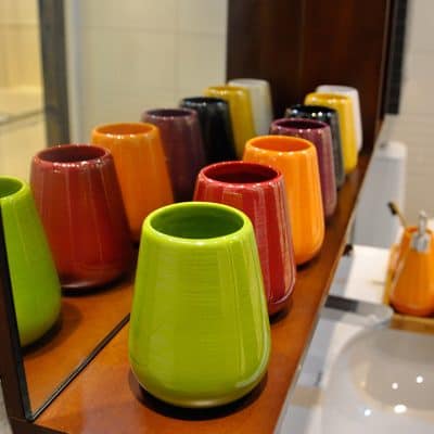 Colorful ceramic vases display at Monalisa Store in vibrant red, yellow, orange, green, and black hues, perfect for decorative home or office accents.