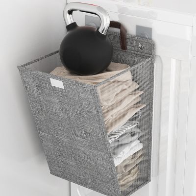 Kettlebell stored in a wall-mounted fabric organizer on laundry room wall, used for fitness routines and home workouts.