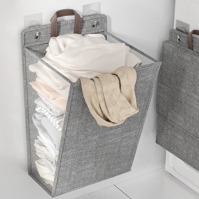 Laundry hamper with folded clothes in a modern home organization setting.
