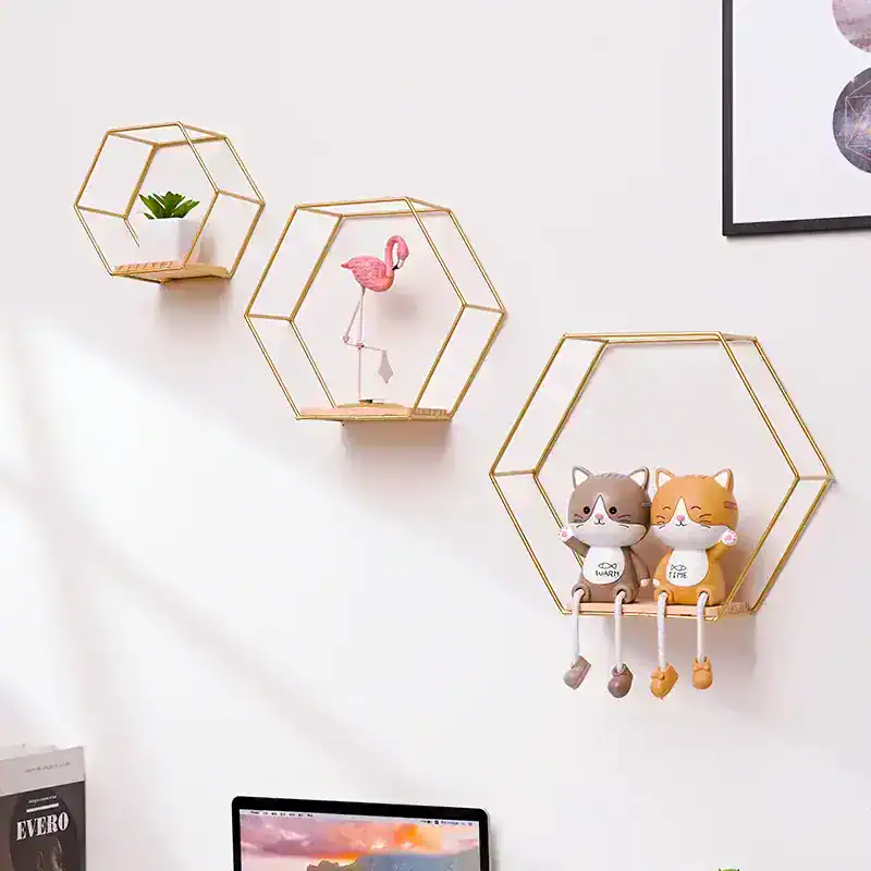 Pink flamingo decorative figure on modern gold hexagonal wall shelf, stylish and playful home decor piece, perfect for living room or bedroom.