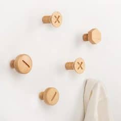 Wooden coat hooks with screw design on white wall, modern minimalistic decor, Monalisa Store opt furniture, stylish organization and home accessories.
