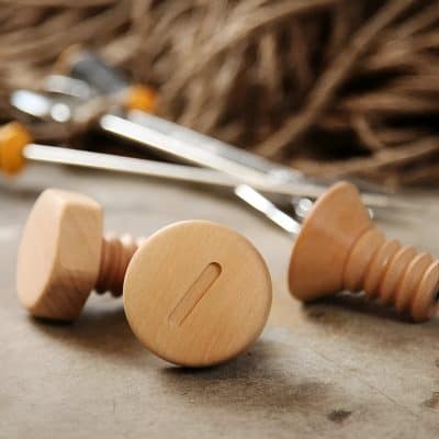 Natural wooden chess pieces on a rustic wooden surface with blurred background, emphasizing classic and elegant design suitable for strategic board games.