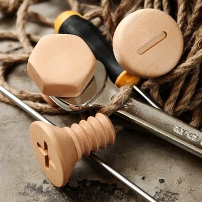 Hexagonal and round wooden wine stoppers with engraved heart and star designs on a metal corkscrew and rustic rope, ideal for elegant wine bottle sealing and gift packaging.