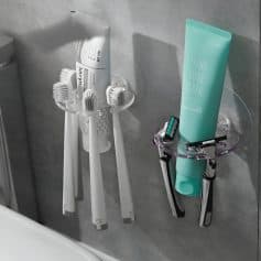 Qwahs toothbrushes and dental hygiene tools on a bathroom wall.
