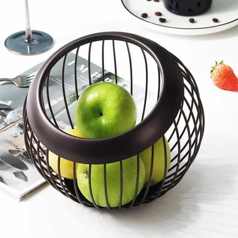 Green apples inside a modern black wire fruit basket.