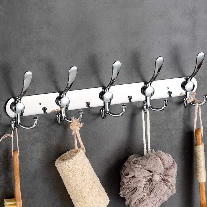Brushed metal hooks with towels and bath accessories on gray wall, modern coat rack, stylish home organization, versatile wall hooks for bathroom or entryway, sleek design for home decor.