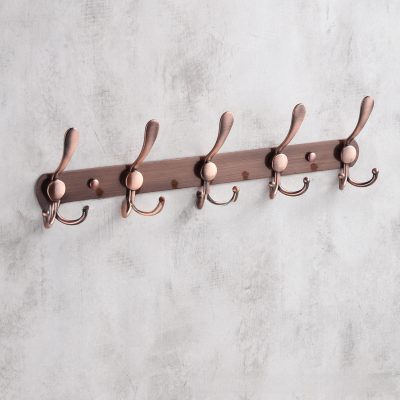 Modern rose gold coat rack with multiple hooks, stylish wall-mounted hooks for home or office decor.