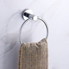 Soft beige towel hanging on a modern chrome towel ring in a bathroom, close-up view.