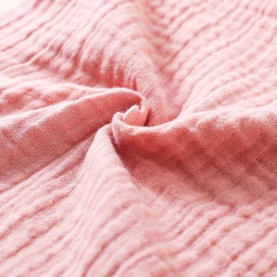 Soft pink textured fabric, ideal for clothing and accessories, featuring a comfortable, lightweight weave perfect for casual wear.