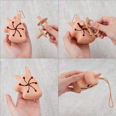 Miniature plush pink rabbit-shaped toy with black design on its body, designed as a pacifier holder, soft silicone material, easy grip, versatile for baby accessories, adorable and functional, perfect for infants and new parents.