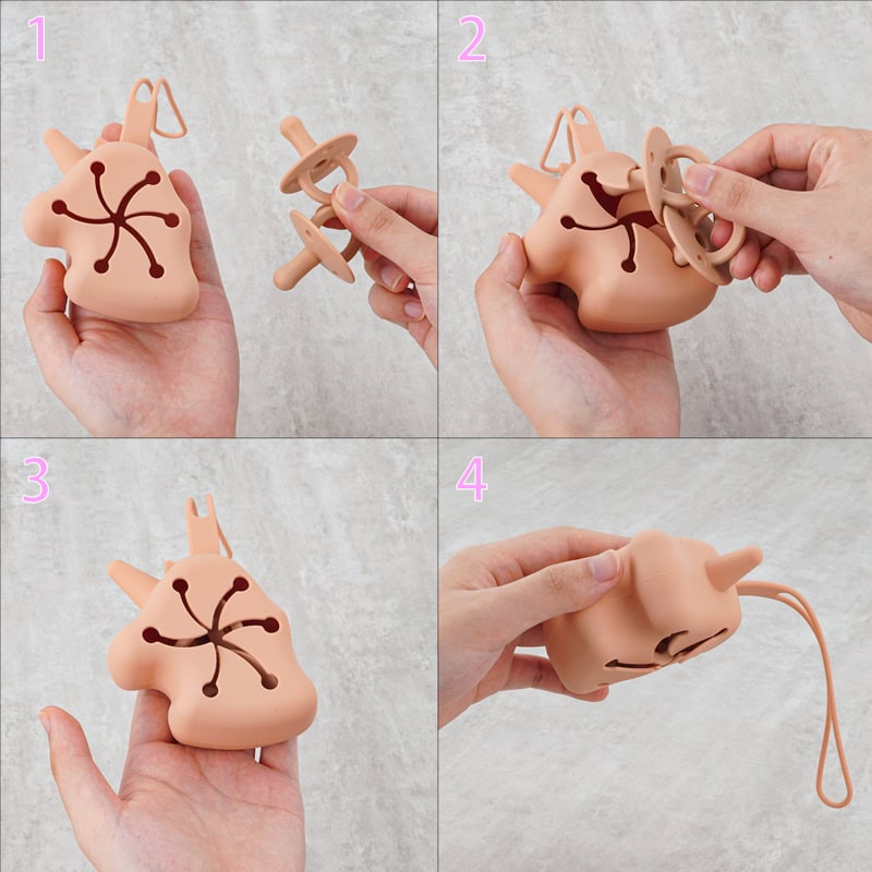 Miniature plush pink rabbit-shaped toy with black design on its body, designed as a pacifier holder, soft silicone material, easy grip, versatile for baby accessories, adorable and functional, perfect for infants and new parents.