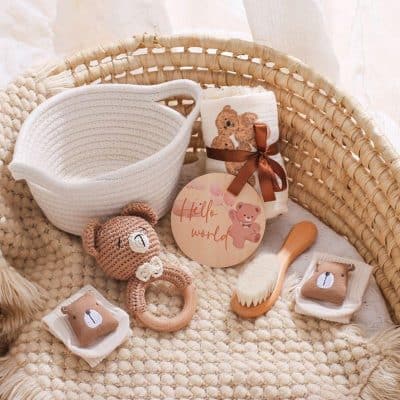 Soft baby care items displayed on cozy woven basket, including plush teddy teething toy, knitted storage, and gentle brushes, perfect for newborn and infant skincare routines.