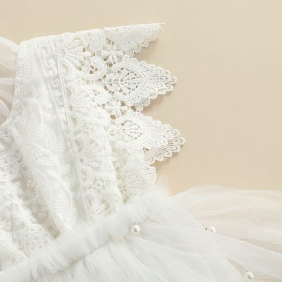 Delicate white lace dress with intricate embroidery and pearl accents, perfect for elegant occasions or bridal wear.