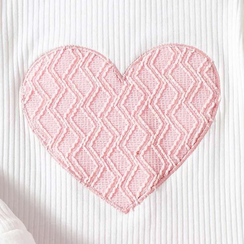Pink heart-shaped plush rug with textured geometric pattern, perfect for home decor and cozy accents. Ideal for adding warmth to living spaces or bedrooms.