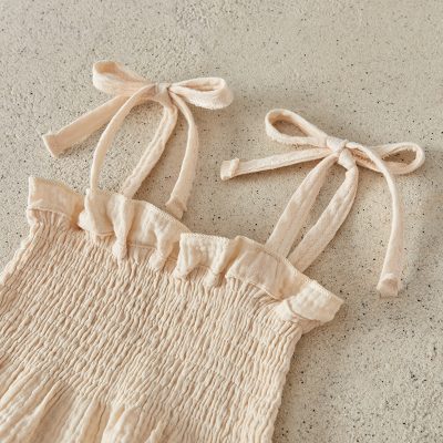 Light beige smock with adjustable shoulder ties and smocking design for comfortable wear at Monalisa Store.