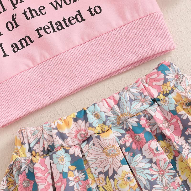 Pink hoodie with text, pastel colors, floral skirt, casual fashion, trendy clothing, Monalisa Store, women's apparel, spring wardrobe, comfortable outfit, stylish casual wear.