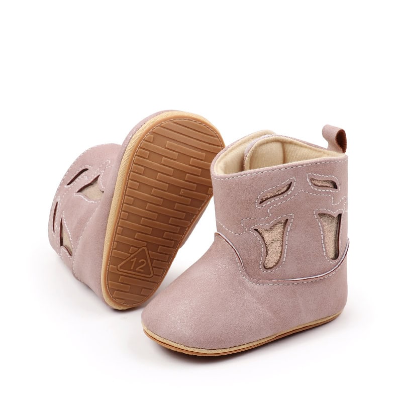 Soft pink baby boots with cut-out leaf design, ideal for infants and toddlers, featuring comfortable slip-resistant soles and durable material for stylish, supportive footwear.