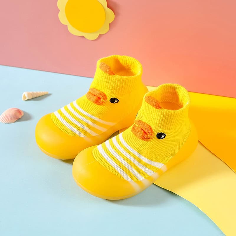 Bright yellow duck-themed baby slippers with sock design, soft and comfortable for infants, featuring cute duck faces, suitable for cozy household wearing.