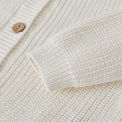 Soft cream knitted sweater with button detail, perfect for fall and winter fashion. Elegant and cozy, suitable for casual wear or office attire. Durable and stylish for everyday comfort.