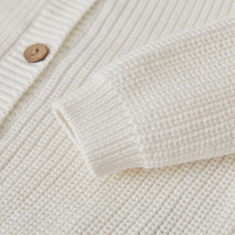 Soft cream knitted sweater with button detail, perfect for fall and winter fashion. Elegant and cozy, suitable for casual wear or office attire. Durable and stylish for everyday comfort.